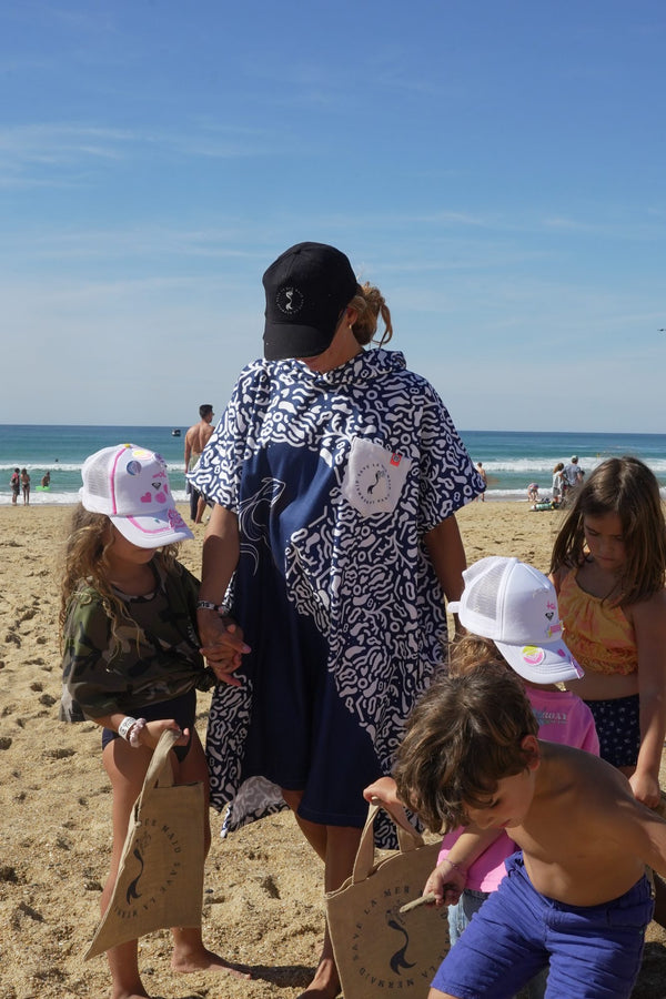Der Poncho Save La Mermaid am Strand unter blauem Himmel