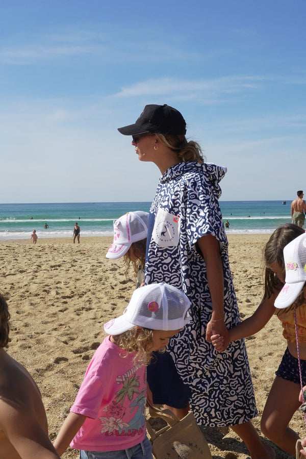 Maud Le Car im Save La Mermaid-Poncho am Strand anlässlich eines Mermaid Day